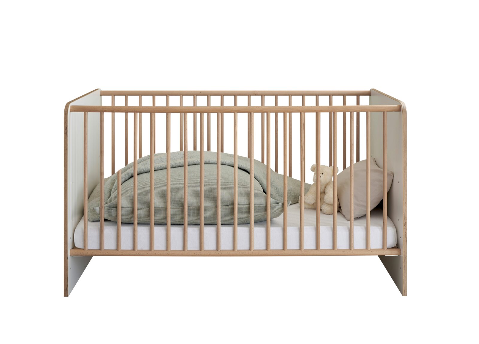 Modernes Babybett/Gitterbett aus hellem Holz mit weißen Seitenteilen, frontal in Studioansicht, mit Matratze, Decke, Kissen und Teddy