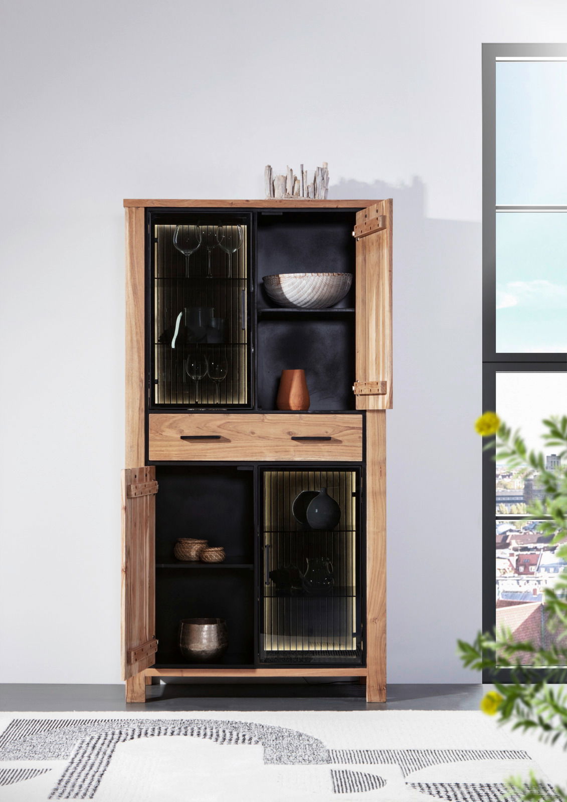 Vitrine aus Holz mit Glastüren, dekoriert mit Geschirr und Accessoires, frontal fotografiert.