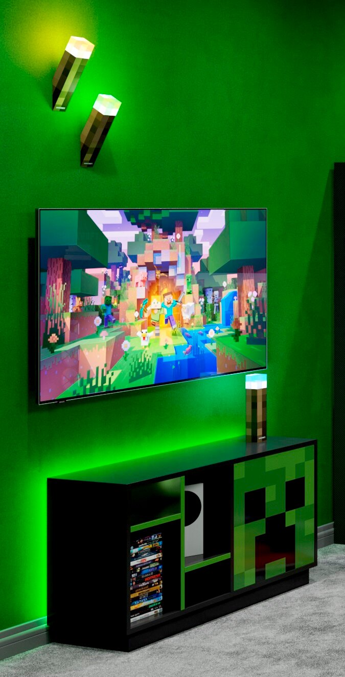 Schwarzes Gaming-TV-Lowboard mit grünem Pixel-Design (Creeper-Motiv) unter einem an der Wand montierten Fernseher, grüne LED-Ambientebeleuchtung und Minecraft-Fackel-Lampen; Perspektive: leicht schräg von vorne.