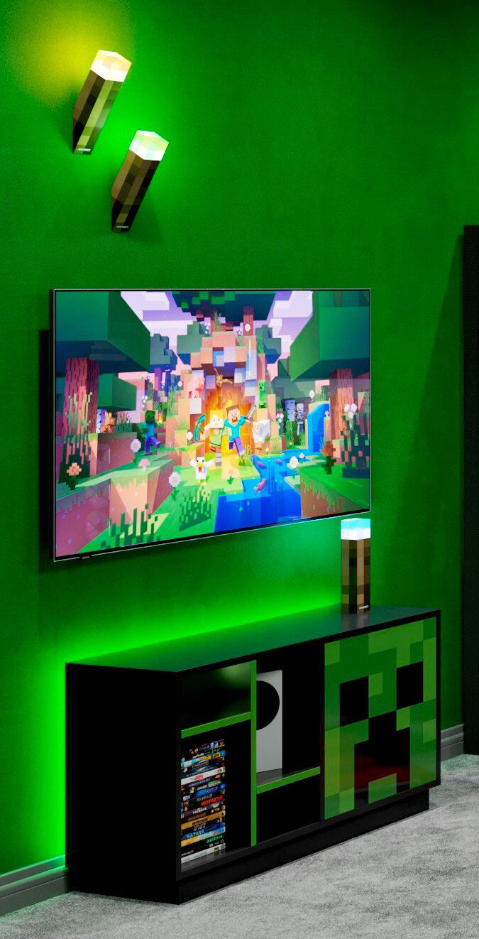 Schwarzes Gaming-TV-Lowboard mit grünem Pixel-Design (Creeper-Motiv) unter einem an der Wand montierten Fernseher, grüne LED-Ambientebeleuchtung und Minecraft-Fackel-Lampen; Perspektive: leicht schräg von vorne.