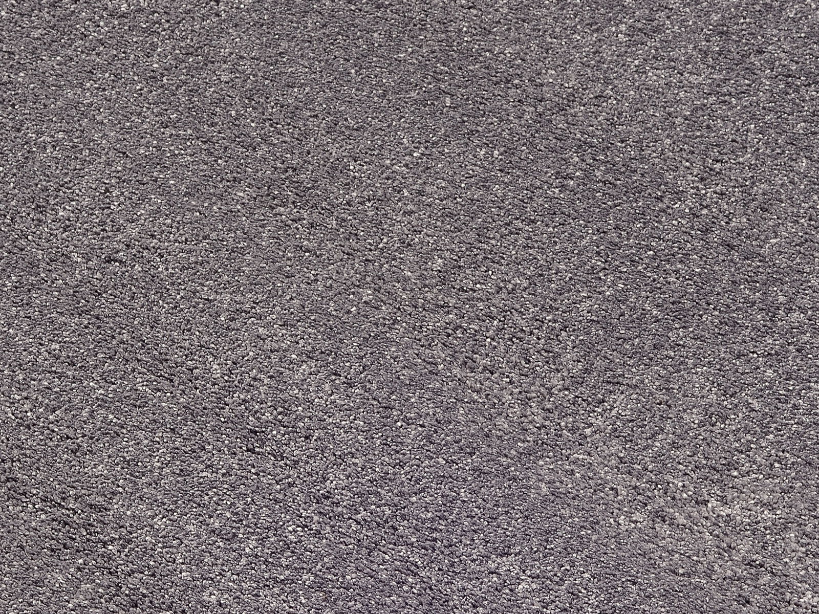 Nahaufnahme eines grauen Uni-Teppichs mit texturierter Oberfläche, von oben betrachtet.