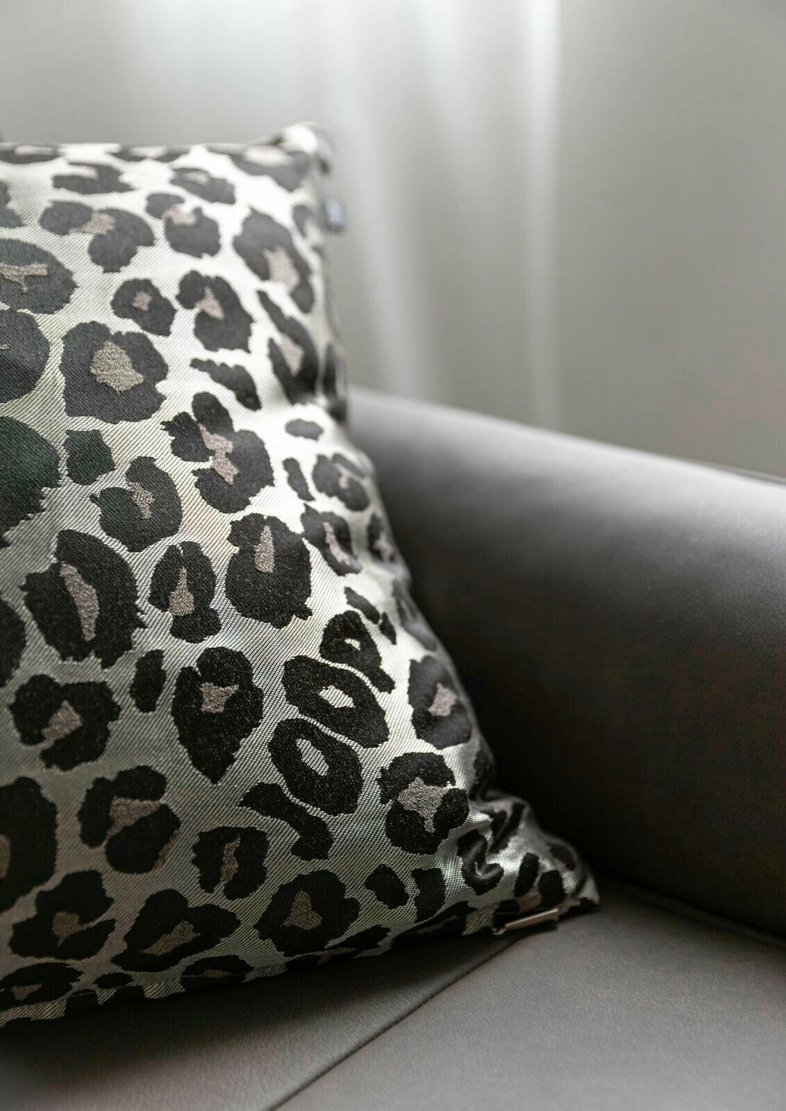 Zierkissenhülle mit Leopardenmuster auf einem Sofa, seitliche Perspektive