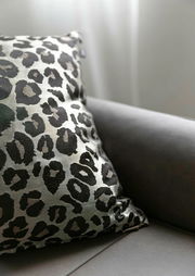Zierkissenhülle mit Leopardenmuster auf einem Sofa, seitliche Perspektive