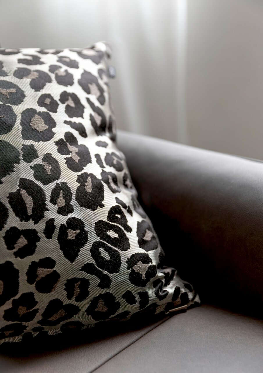 Zierkissenhülle mit Leopardenmuster auf einem Sofa, seitliche Perspektive