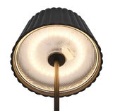 Nahaufnahme der Unterseite einer stilvollen Akku-Stehleuchte SUAREZ mit schwarzem, geripptem Lampenschirm und leuchtendem LED-Ring, von unten betrachtet.