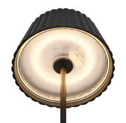 Nahaufnahme der Unterseite einer stilvollen Akku-Stehleuchte SUAREZ mit schwarzem, geripptem Lampenschirm und leuchtendem LED-Ring, von unten betrachtet.