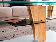Moderner Couchtisch mit Glasplatte und Holzdetails, seitliche Perspektive