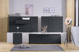 Modernes Sideboard-Set in dunklem Grau, bestehend aus mehreren Schränken und Schubladen, in einem stilvoll eingerichteten Raum mit Holzfußboden und dekorativen Elementen. Frontalansicht.