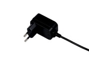 Schwarzes Steckernetzteil mit Eurostecker und angeschlossenem Kabel, angeschnittene Nahaufnahme aus schräger Seitenansicht vor weißem Hintergrund