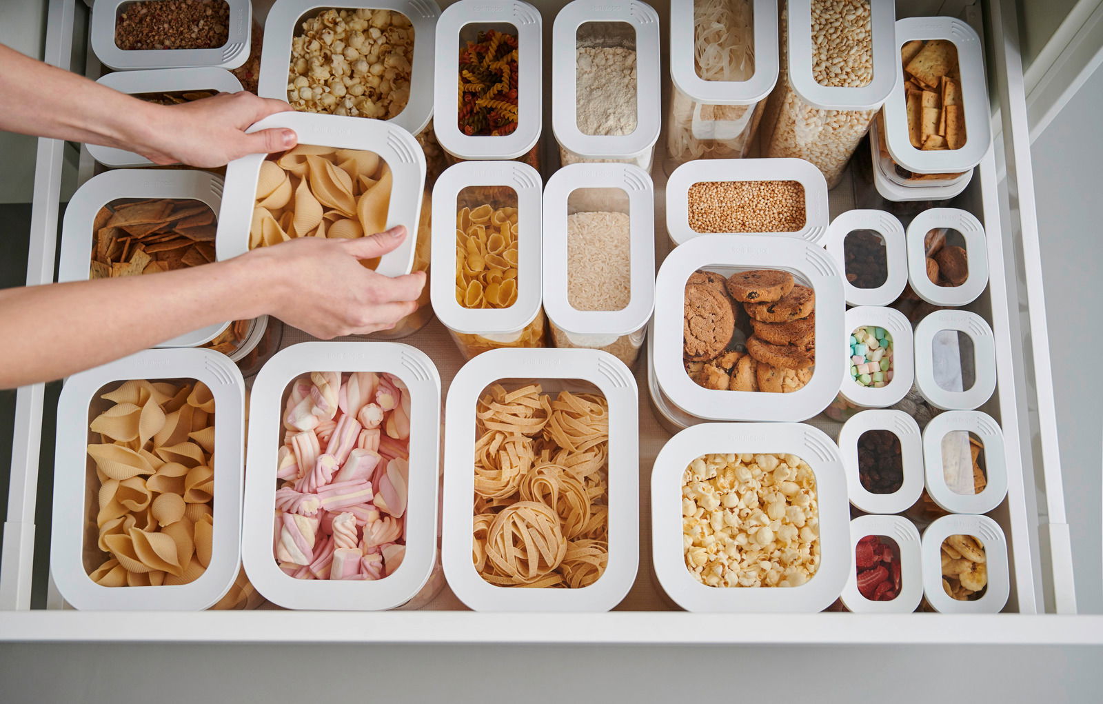 Mepal Vorratsdosen-Set Modula 7-tlg. Vorratsdosen-Set Modula 7-tlg in einer Schublade, gefüllt mit verschiedenen Lebensmitteln wie Nudeln, Keksen und Popcorn, aus der Vogelperspektive betrachtet.