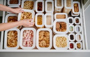Vorratsdosen-Set Modula 7-tlg in einer Schublade, gefüllt mit verschiedenen Lebensmitteln wie Nudeln, Keksen und Popcorn, aus der Vogelperspektive betrachtet.
