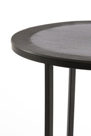 Nahaufnahme eines runden Beistelltisches mit schwarzer Metalloberfläche und schlanken Beinen, seitliche Perspektive.