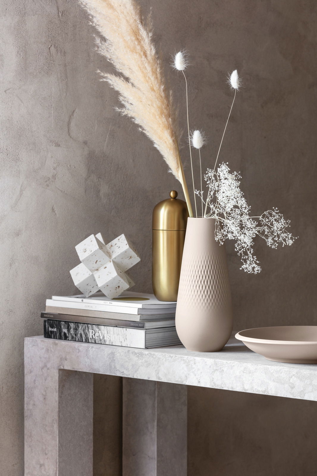 Beige Schale NewMoon 750ml auf einem Tisch, seitliche Perspektive, neben einer Vase mit Trockenblumen und einem goldenen Behälter.