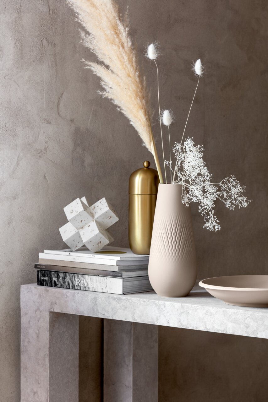 Beige Schale NewMoon 750ml auf einem Tisch, seitliche Perspektive, neben einer Vase mit Trockenblumen und einem goldenen Behälter.