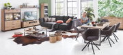 Wohnzimmer mit modernen Möbeln in Holzoptik, bestehend aus einer Vitrine, einem TV-Lowboard, einem Couchtisch und einem Esstisch mit Stühlen. Perspektive: Frontalansicht des gesamten Raumes.
