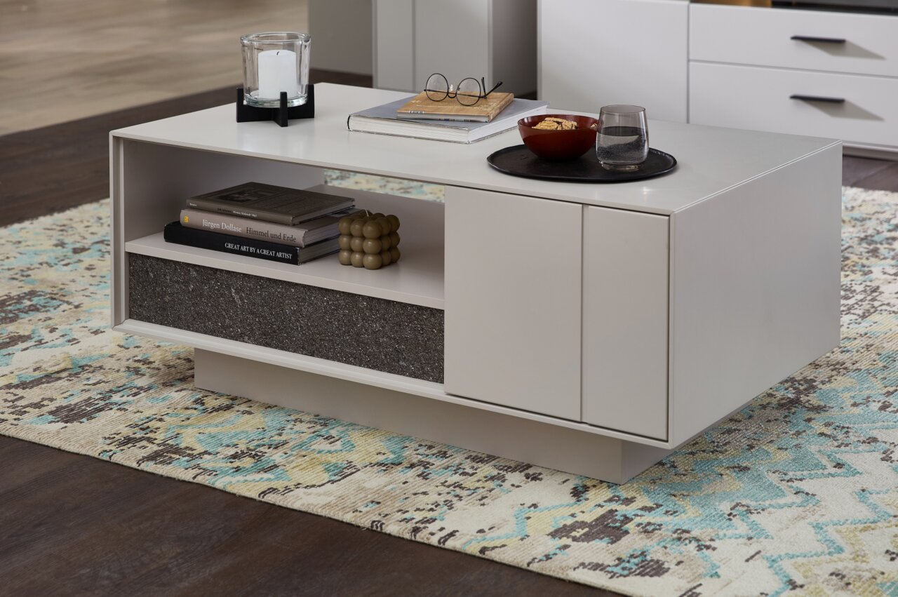 Moderner Couchtisch in hellem Design mit offener Ablage und dekorativen Gegenständen, seitliche Perspektive