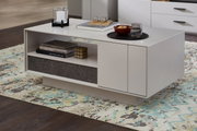 Moderner Couchtisch in hellem Design mit offener Ablage und dekorativen Gegenständen, seitliche Perspektive