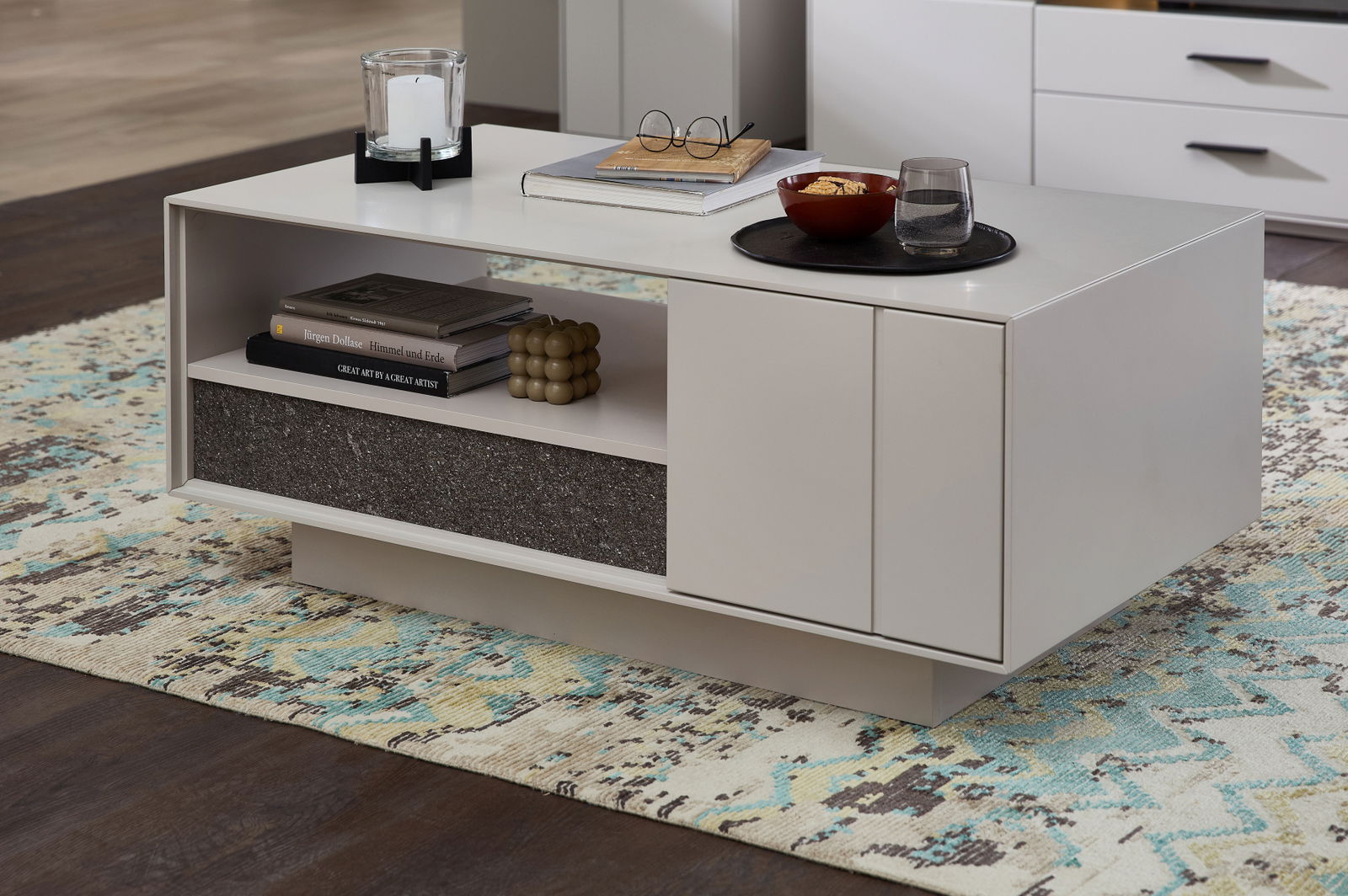 Moderner Couchtisch in hellem Design mit offener Ablage und dekorativen Gegenständen, seitliche Perspektive