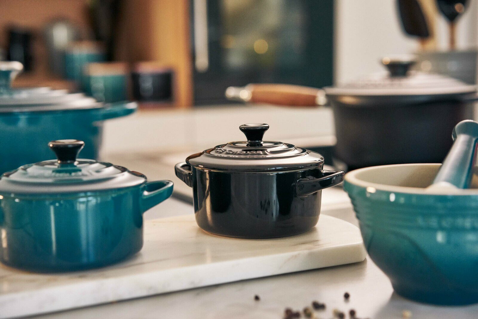 Schwarze Mini-Cocotte auf einer Küchenarbeitsplatte, seitliche Perspektive