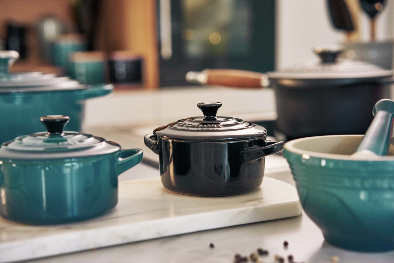 Schwarze Mini-Cocotte auf einer Küchenarbeitsplatte, seitliche Perspektive
