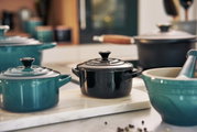 Schwarze Mini-Cocotte auf einer Küchenarbeitsplatte, seitliche Perspektive