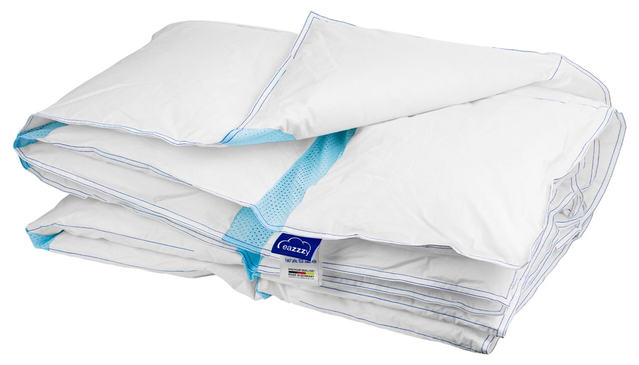 Opgevouwen wit dekbed/quilt met blauw mesh-inzetstuk en eazzzy-label, vrijstaand op een witte achtergrond, schuin van voren/bovenaf gezien.