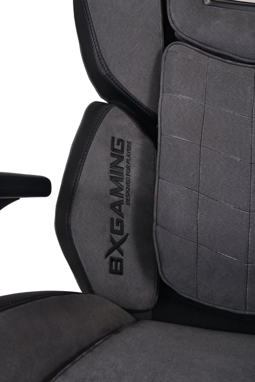 BXGAMING Gaming Stuhl HAYDEN Nahaufnahme eines grauen Gaming-Stuhls mit gesticktem Logo 'BX Gaming' auf der Rückenlehne, seitliche Perspektive.