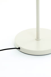 Nahaufnahme der Basis einer weißen Stehleuchte mit schwarzem Kabel