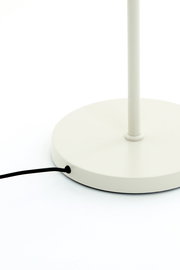 Nahaufnahme der Basis einer weißen Stehleuchte mit schwarzem Kabel