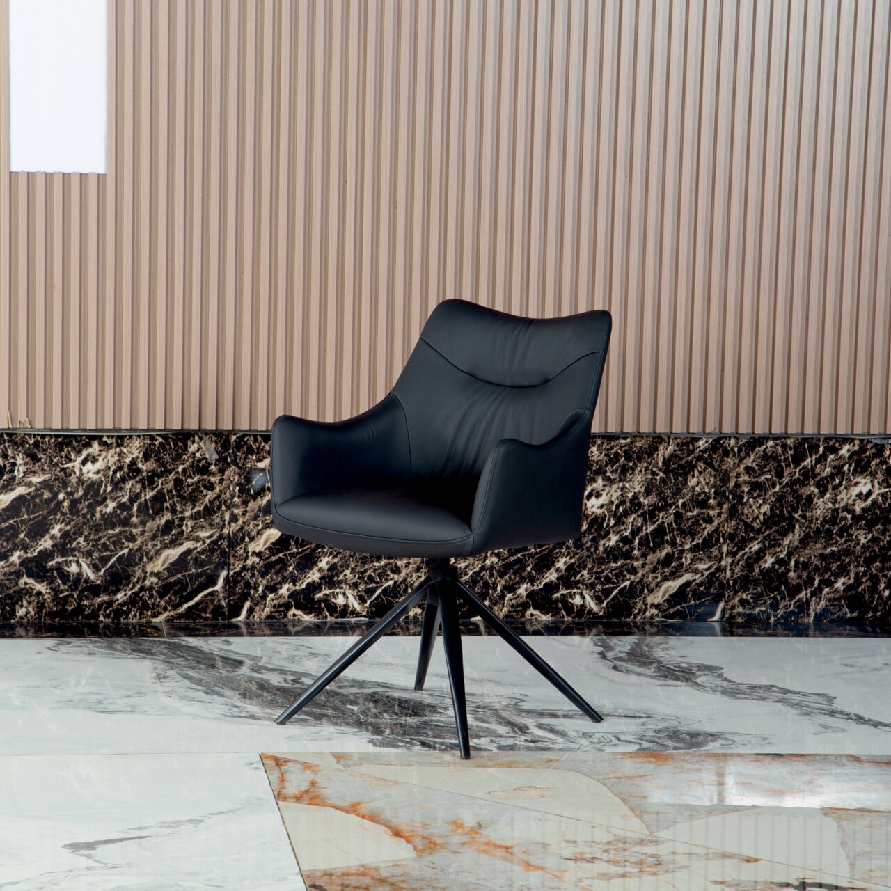 Zwarte fauteuil met een modern ontwerp, op een marmeren vloer voor een geribbelde muur, gezien van voren.