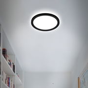 Runde LED-Deckenleuchte mit schwarzem Rahmen, von unten betrachtet, in einem modernen Raum installiert.