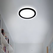 Runde LED-Deckenleuchte mit schwarzem Rahmen, von unten betrachtet, in einem modernen Raum installiert.