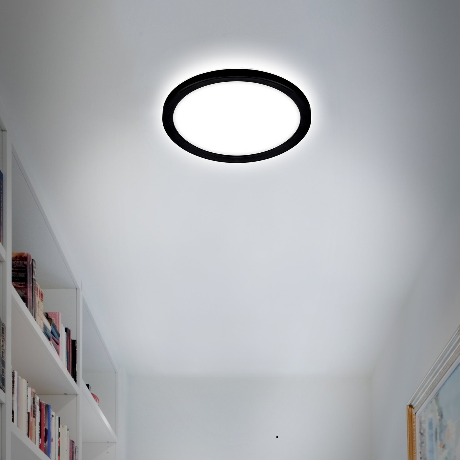 Runde LED-Deckenleuchte mit schwarzem Rahmen, von unten betrachtet, in einem modernen Raum installiert.
