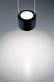 Zwarte, cilindervormige hanglamp, gezien van bovenaf, met een heldere lichtstraal tegen een grijze achtergrond.