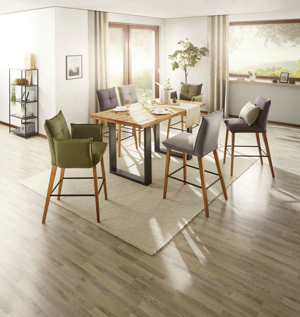 Moderner Tresentisch aus Holz mit Metallgestell, umgeben von stilvollen Barhockern in einem hellen, gemütlichen Raum mit großen Fenstern. Perspektive: seitlich von oben.