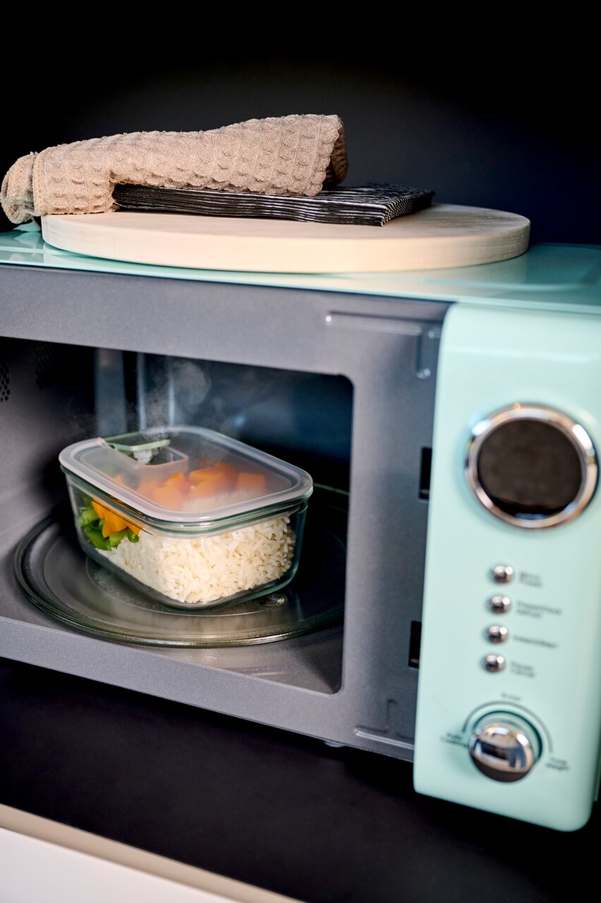 Glas Frischhaltedose Easyclip mit Reis und Gemüse in einer Mikrowelle, seitliche Perspektive
