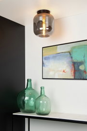 Plafondlamp JOANET met rookgrijs glas en warm licht, gezien van onderaf.