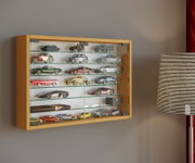 Wandvitrine aus hellem Holz mit Glasfront und mehreren Glasböden, gefüllt mit Modellautos; Ansicht leicht von rechts vorn.