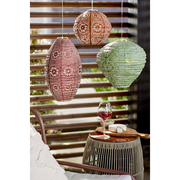 Drei hängende Solar-Laternen in verschiedenen Farben und Mustern, im Freien mit einem Glas Rotwein und Käse auf einem Tisch im Vordergrund.