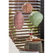 Drei hängende Solar-Laternen in verschiedenen Farben und Mustern, im Freien mit einem Glas Rotwein und Käse auf einem Tisch im Vordergrund.