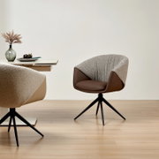 Moderne fauteuil met bruine zitting en rugleuning van stof met patroon, op een zwart draaipootonderstel, gezien vanaf de zijkant in een minimalistische ruimte.