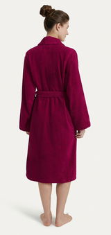 Rückansicht eines weinroten Bademantels mit Schalkragen, getragen von einer Person mit hochgestecktem Haar.