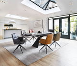 Moderner Design-Schalensessel in einem stilvollen Esszimmer, umgeben von weiteren Sesseln und einem Esstisch, aus der Perspektive eines hellen, offenen Raumes mit großen Fenstern.