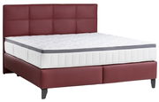 Boxspringbett mit rotem Kopfteil und weißer Matratze, seitliche Perspektive