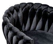 Nahaufnahme eines Sessels mit geflochtenem, schwarzem Samtbezug, seitliche Perspektive