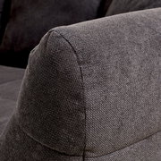 Nahaufnahme eines grauen Big-Sofas mit strukturiertem Stoffbezug, seitliche Perspektive auf die Armlehne.