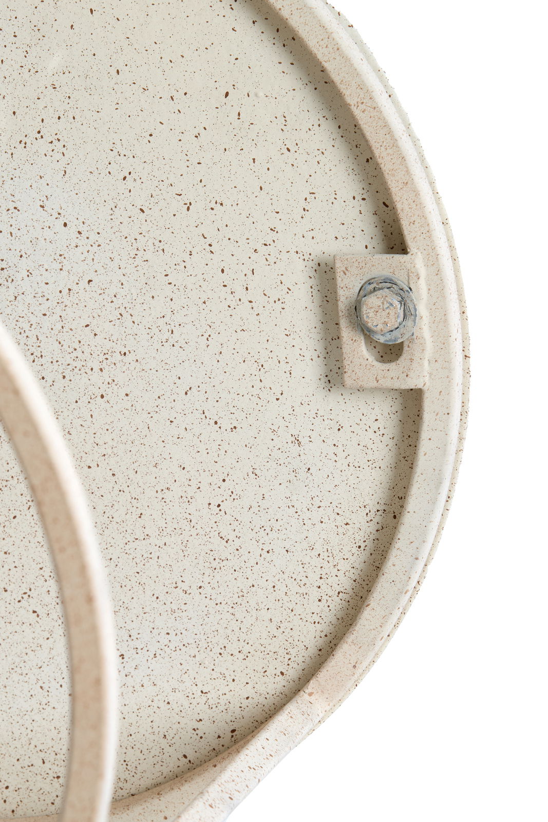 Nahaufnahme eines Couchtischs mit gesprenkelter Oberfläche und sichtbarer Schraube, von oben betrachtet.