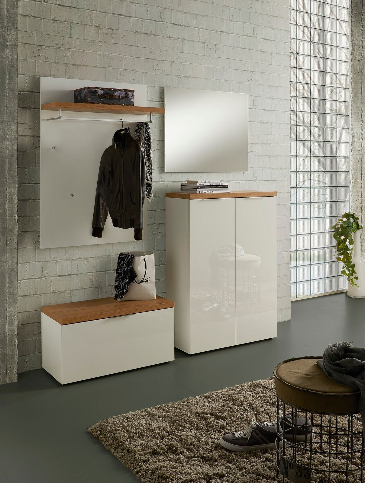 Moderne Garderobeneinrichtung mit weißem Garderobenpaneel, Spiegel und Schuhschrank in einem hellen Raum, seitliche Perspektive