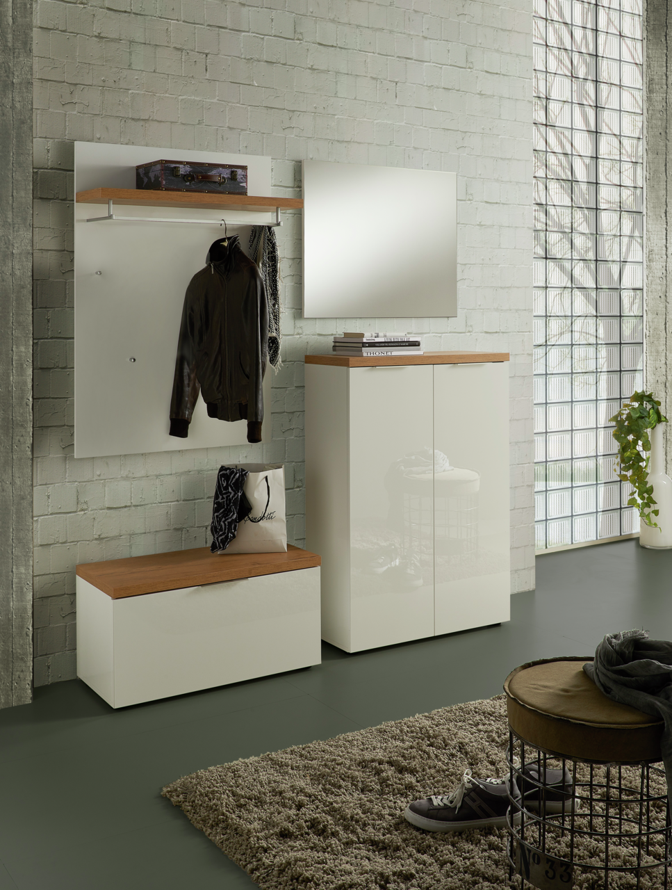 Moderne Garderobeneinrichtung mit weißem Garderobenpaneel, Spiegel und Schuhschrank in einem hellen Raum, seitliche Perspektive