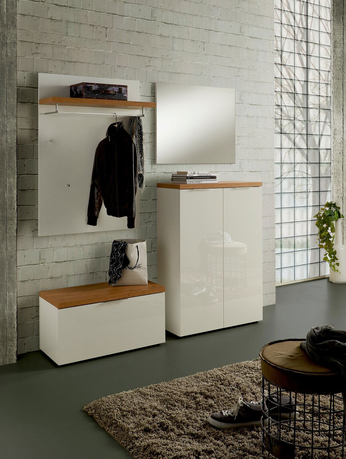 Moderne Garderobeneinrichtung mit weißem Garderobenpaneel, Spiegel und Schuhschrank in einem hellen Raum, seitliche Perspektive